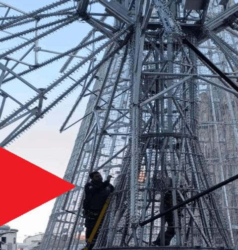 Caballero corona el árbol de Navidad con una estrella con mucha luz pero poca seguridad